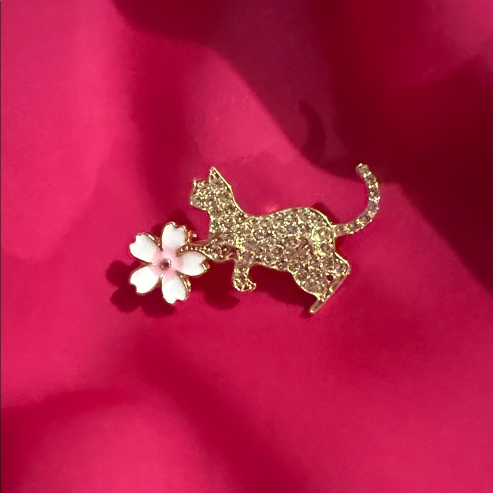 Rhinestone Cat playing with a Flower Brooch